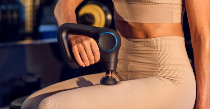 Theragun Mini on a wood surface